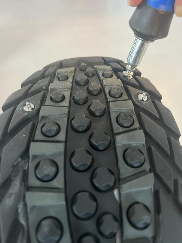 Et skruverktøy som skrur en brodd i en såle